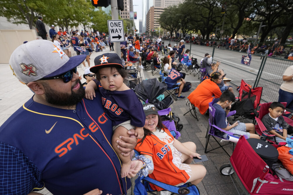 Luis Varela holds his 10-month-old son Joaquin as fans wait for a victory parade for the Houston Astros' World Series baseball championship Monday, Nov. 7, 2022, in Houston. (AP Photo/David Phillip)