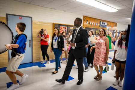 Austin ISD Interim Superintendent Dr. Anthony Mays walks with the McCallum High School marching band as they perform on the first day of school on Aug. 15, 2022. Renee Dominguez/KUT