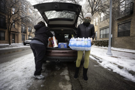 Jacqueline Fabian (left), an Instacart shopper for Costco, makes a water and grocery delivery to Kristin Rash (right) during a winter storm on Feb. 18, 2021. Rash, who has been living at an apartment at the Triangle on Guadalupe without water, didn't expect an Instacart order she placed last week to come through this week due to the storm. But this morning, she received an update saying Fabian would fill her order. "I texted her and I said 'I only want you to do this if you can do it safely,'" said Rash. Fabian replied that she was already at Costco and would fill the order. When Rash found out that Fabian also had no water at home, she said, "Please get whatever you need for your family and put it on my tab." Fabian said she pushes through orders during the storm becuase of people like Rash. "When you help people, they pay it forward," she said. The two women exchanged phone numbers and expressed gratitude for having met one another. Julia Reihs/KUT