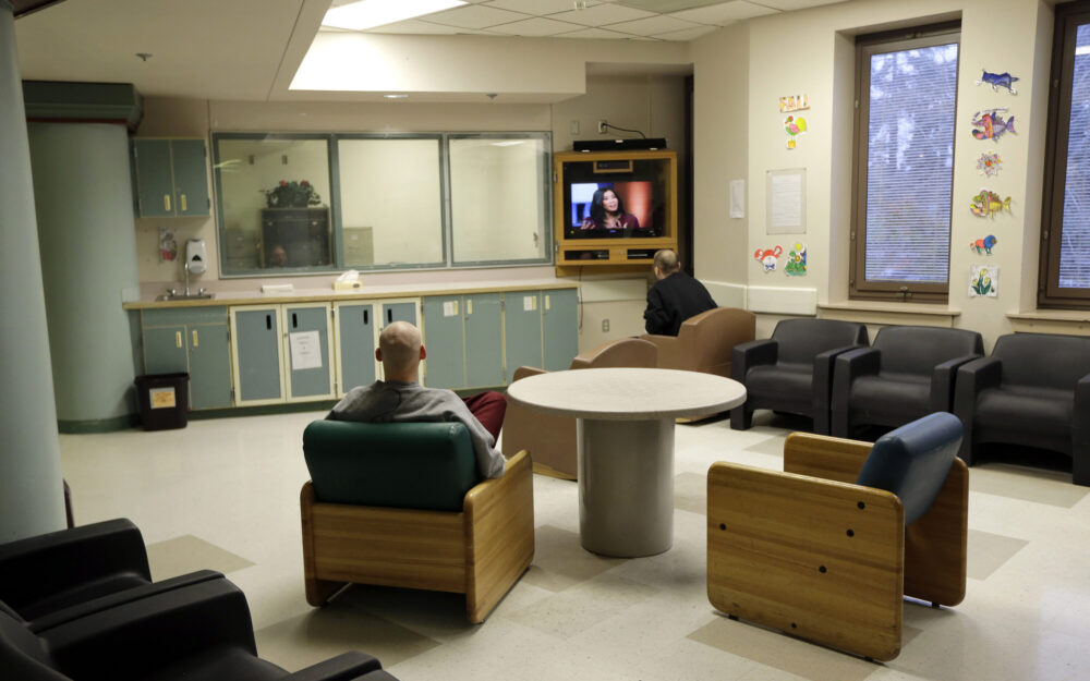FILE - In this Nov. 18, 2015, file photo, patients at Western State Hospital in Lakewood, Wash., watch television. Hundreds of employees at Washington state's largest psychiatric hospital have suffered serious injuries during assaults by patients, resulting in millions of dollars in medical costs and thousands of missed days of work. 