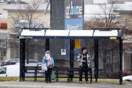 A woman and a man wait for the bus in Dallas, Texas on Thursday, December 22, 2022.