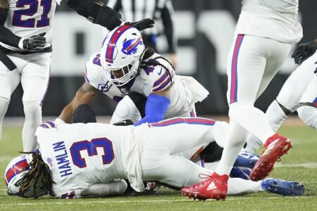 Buffalo Bills safety Damar Hamlin (3) lies on the turf after making a tackle on Cincinnati Bengals wide receiver Tee Higgins, blocked from view, as Buffalo Bills linebacker Tremaine Edmunds (49) assists at the end of the play during the first half of an NFL football game between the Cincinnati Bengals and the Buffalo Bills, Monday, Jan. 2, 2023, in Cincinnati. After getting up from the play, Hamlin collapsed and was administered CPR on the field.