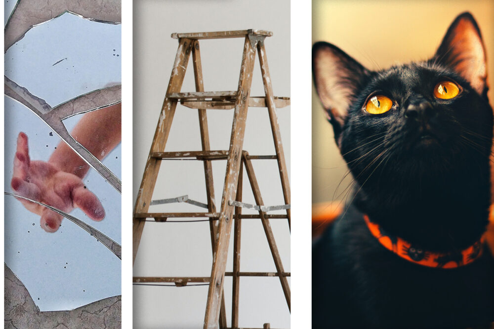 A broken mirror, a ladder, and a black cat