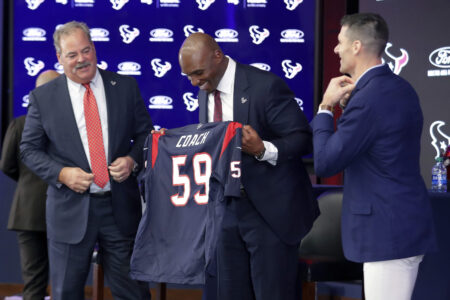 Newly named Texans head coach DeMeco Ryans, center, is presented a jersey by team owner Cal McNair, left, and general manager Nick Caserio, right, during a press conference formally announcing Ryans as the new head coach at NRG Stadium, Thursday, Feb. 2, 2023, in Houston.