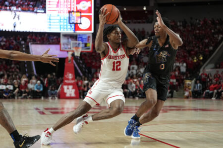 Houston guard Tramon Mark (12) drives around Memphis guard Elijah McCadden (0) during the second half of an NCAA college basketball game, Sunday, Feb. 19, 2023, in Houston.