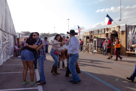 A group of people greeting each other at Houston Livestock Show and Rodeo Barbecue Cookoff.