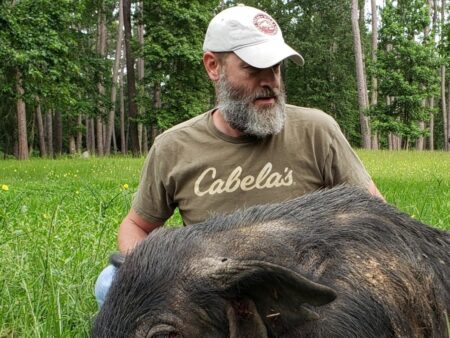 Texas Wild Hog Patrol's Edward Dickey with a captured wild hog.