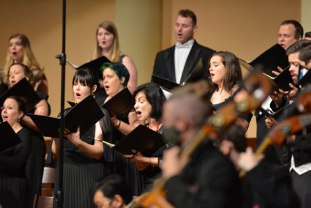 Photo of chorus singers and orchestra performing