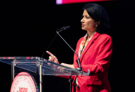 UH Chancellor Dr. Renu Khator stands at a lectern delivering a speech.
