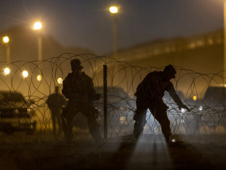 Texas National Guard troops set up razor wire near hundreds of immigrants who had crossed into the United States from Mexico on May 09, 2023 in El Paso, Texas. A surge of immigrants is expected with the end of the U.S. government's Covid-era Title 42 policy, which for the past three years has allowed for the quick expulsion of irregular migrants entering the country. (Photo by John Moore/Getty Images)