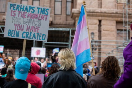 Rally participants holds a sign with the words, “Perhaps this is the moment for which you have been created,” in support of LGBTQ on the Texas Capitol steps to protest anti-LGBTQ legislation on March 20, 2023 in Austin, Texas. Alyssa Olvera/KUT