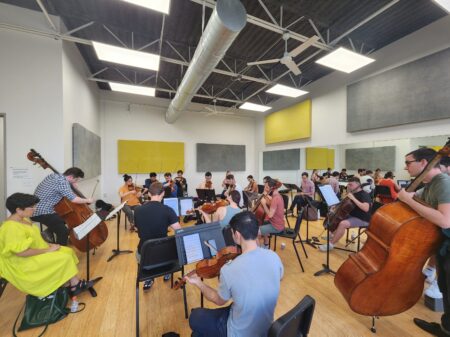 Photo of string orchestra musicians rehearsing