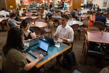 Nicole Ma, Steven Wu and Quỳnh-Hương Nguyễn of Woori Juntos set up their laptops to catch up on emails and online meetings at the Capitol Grill while they wait for the Senate to convene on May 22, 2023.