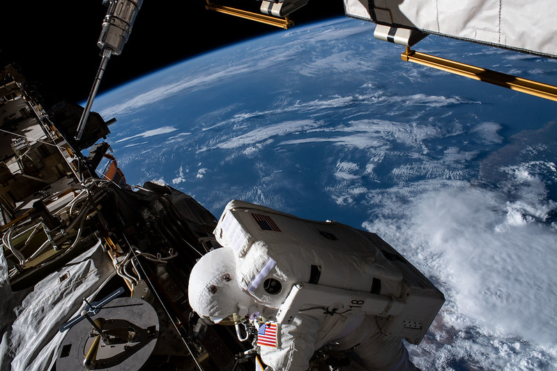 Photo of astronaut outside ISS above planet Earth