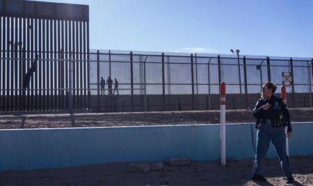 A US law enforcement officer stands guard by a fence at the border with Mexico in El Paso, Texas, on December 22, 2022. - The US Supreme Court halted December 19, 2022 the imminent scrapping of a key policy used since Donald Trump's administration to block migrants at the southwest border, amid worries over a surge in undocumented immigrants. An order signed by Chief Justice John Roberts placed an emergency stay on the removal planned for December 21, 2022 of Title 42, which allowed the government to use Covid-19 safety protocols to summarily block the entry of millions of migrants. (Photo by Allison Dinner / AFP) (Photo by ALLISON DINNER/AFP via Getty Images)