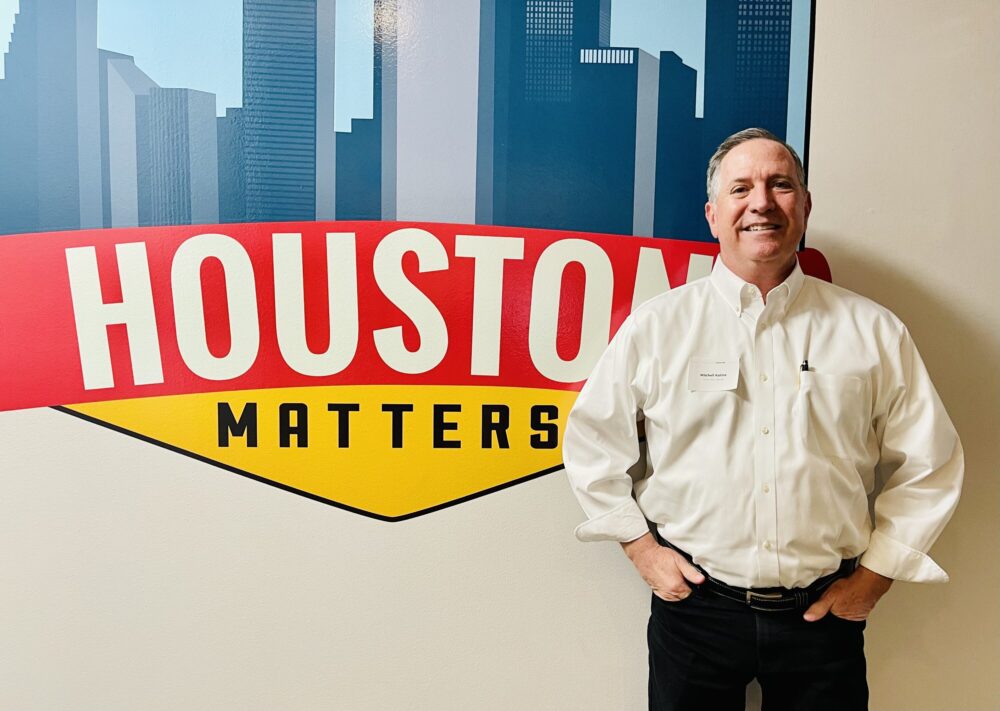 Houston attorney Mitchell Katine stands in front of the Houston Matters logo