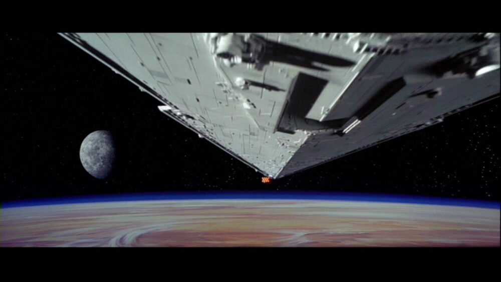 Still from Star Wars showing Star Destroyer pursuing Tantive IV