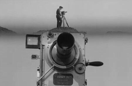 A man with a movie camera in black and white