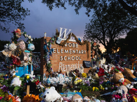 The sun sets behind the memorial for the victims of the massacre at Robb Elementary School in August 2022 in Uvalde, Texas.