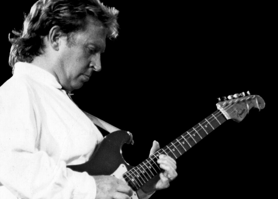 A black-and-white photo of Andy Summers of The Police playing guitar
