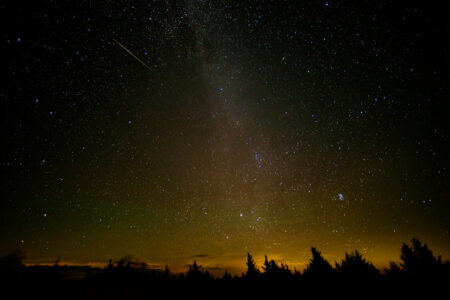 Photo of the night sky with a meteor streaking across