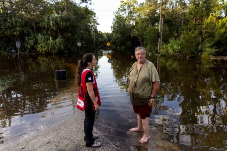 A Red Cross volunteer in Florida talks with a resident in a flooded area.