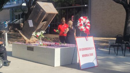 Students and faculty lay flowers at a memorial for the September 11, 2001 attacks.