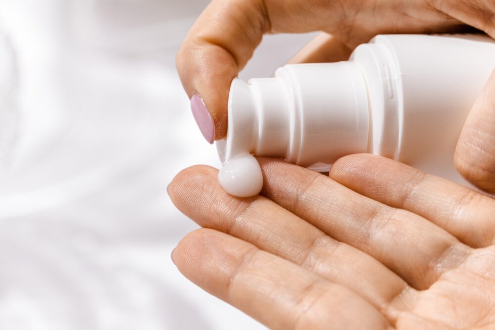 A closeup of a woman's hands applying lotion