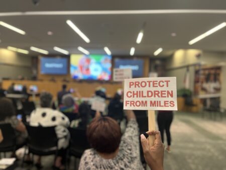Houston Federation of Teachers President Jackie Anderson holds up a sign at HISD's meeting.