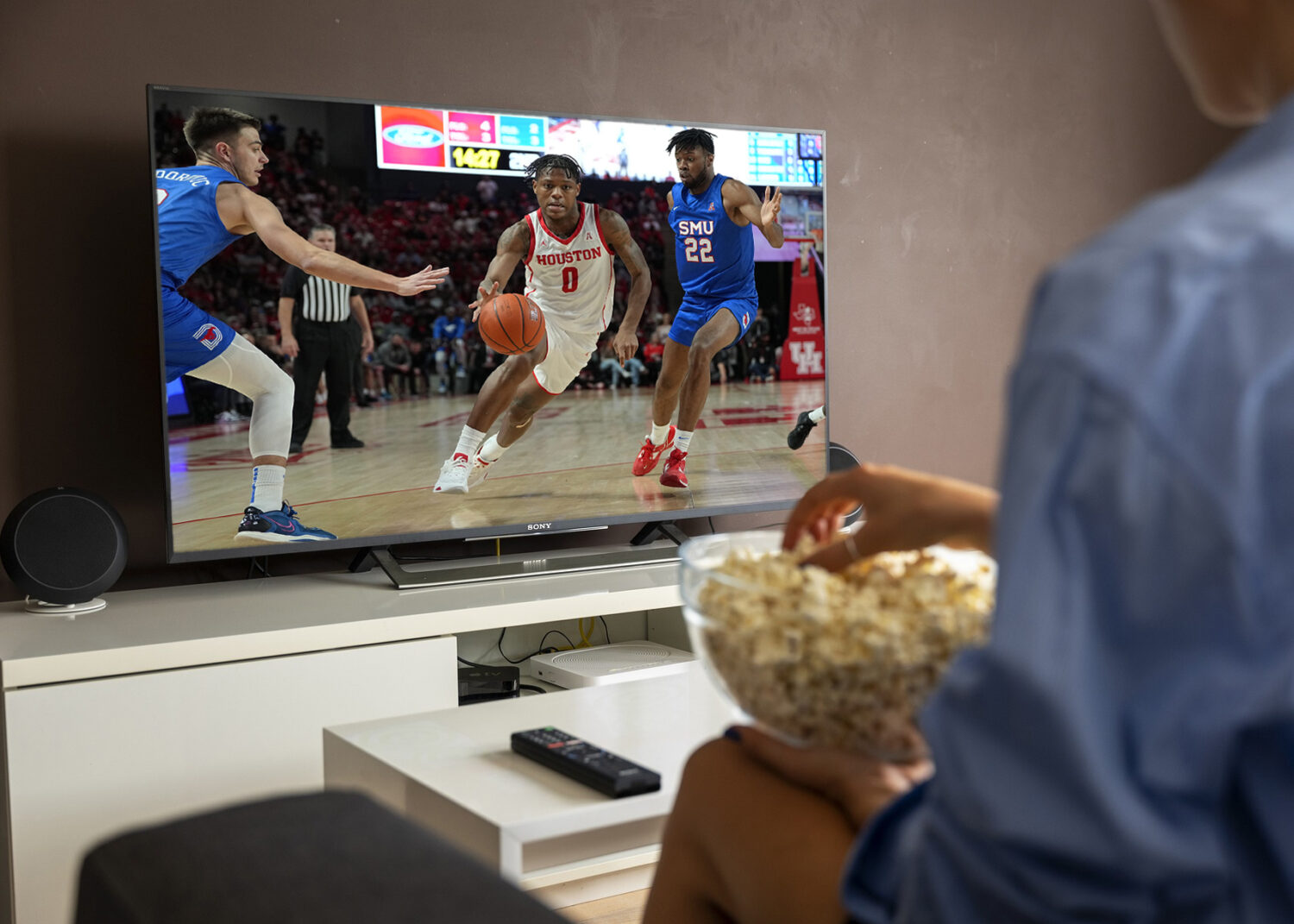 A person watching a basketball game on TV