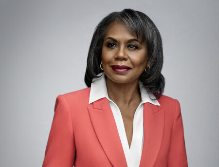 Anita Hill in a red blazer against a gray background