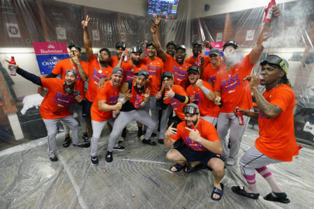 Houston Astros players celebrate in the locker room after clinching the AL West title after a baseball game against the Arizona Diamondbacks, Sunday, Oct. 1, 2023, in Phoenix.