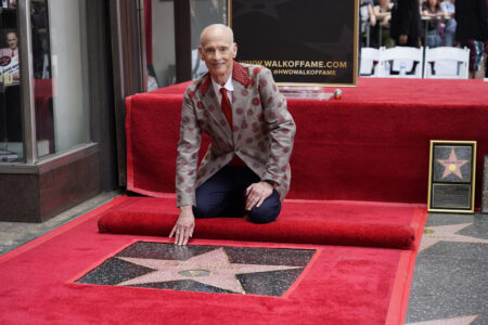 John Waters poses with his new star during a ceremony on the Hollywood Walk of Fame Monday, Sept. 18, 2023, in Los Angeles.
