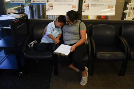 Sebastian Ramirez, 5, is comforted by his mother, Arely, in the school office after he learned that he was scheduled for the Pfizer COVID-19 vaccine at a pediatric vaccine clinic for children ages 5 to 11 set up at Willard Intermediate School in Santa Ana, Calif., Nov. 9, 2021. Health systems have released little data on the racial breakdown of youth vaccinations, and community leaders fear that Black and Latino kids are falling behind. (AP Photo/Jae C. Hong)