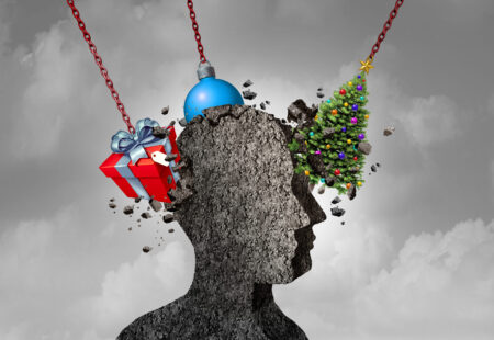 Holiday headache as a human head shape made of concrete being pounded by christmas symbols as a seasonal depression and stress concept as a 3D illustration.