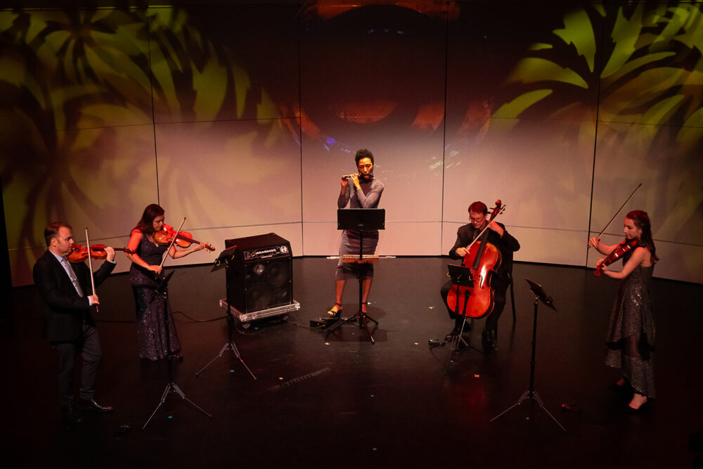 String quartet and flute player performing on stage