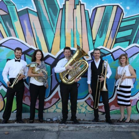 Photo of brass quintet in front of outdoor mural