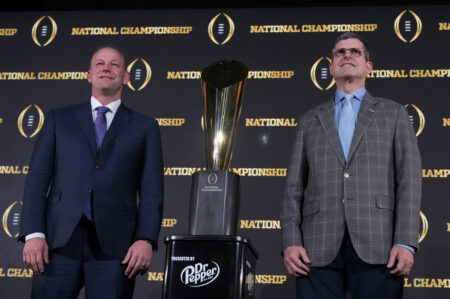 Washington head coach Kalen DeBoer, left, and Michigan head coach Jim Harbaugh pose with the trophy after a news conference ahead of the national championship NCAA College Football Playoff game between Washington and Michigan Sunday, Jan. 7, 2024, in Houston. The game will be played Monday. (AP Photo/Godofredo A. Vasquez)