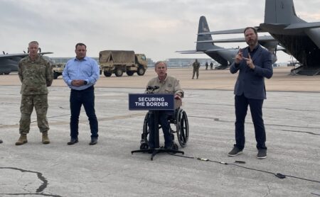Gov. Greg Abbott talks to reporters at the Austin-Bergstrom International Airport on May 8, 2023, after announcing the deployment of a new Texas National Guard unit called Texas Tactical Border Force.