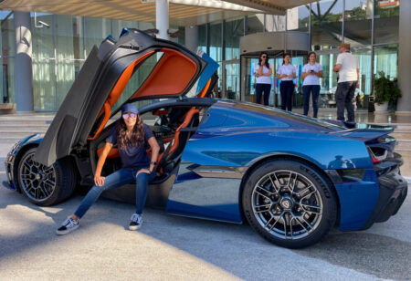 Diane Caplan posing in a blue sports car