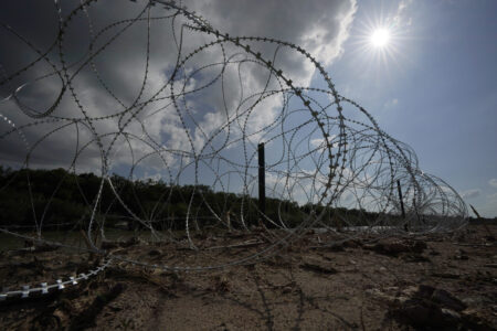 FILE - Concertina wire lines the banks of the Rio Grande on the Pecan farm of Hugo and Magali Urbina, near Eagle Pass, Texas, Monday, July 7, 2023. A dispute over razor wire that Texas installed on the U.S.-Mexico border to deter migrants continued Thursday, Nov. 30, 2023, after a judge allowed Border Patrol agents to continue cutting the barrier but also laid into the Biden administration over immigration enforcement. (AP Photo/Eric Gay, File)
