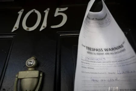 A writ of possession is taped to the door of an apartment at the Life at Jackson Square apartments on April 11, 2023, in Houston. Credit: Annie Mulligan for The Texas Tribune