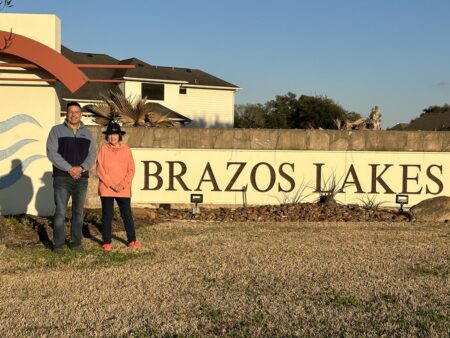 Jesse Cuellar and Anne Franson stand at the entrance of the Brazos Lakes neighborhood.