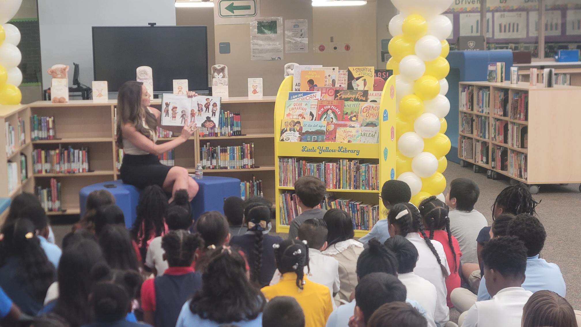 Fox 24's Caroline Collins reads to Hearne Elementary Schoolers during the Little Yellow Library Unveiling