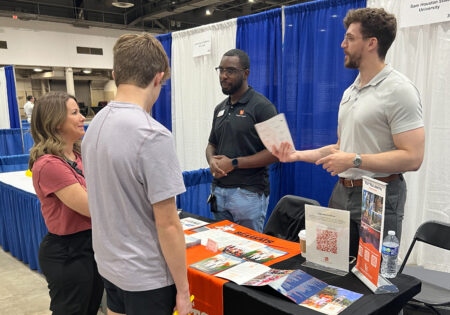 Representatives from Sam Houston State University talk with a prospective student