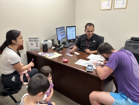 Asif Maruf helps Amanda and Terry Evans complete passport applications for their children, Eli and Ava on April 19, 2024 at the Fort Bend District Clerk's Office. Terry Evans also applied for his first ever passport.