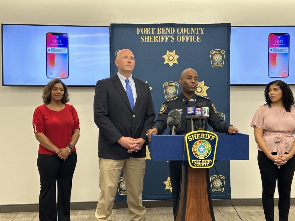 Fort Bend County Sheriff Eric Fagan announces a new mobile app with OCV partner Kevin Cummings and sheriff's office spokespersons Michelle Domengoni (left) and Brionna Rivers (right).