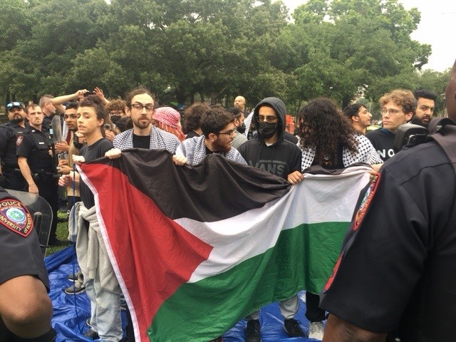 Protesters hold up a Palestine flag