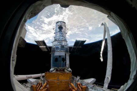 The Hubble Space Telescope in 2009, locked in a space shuttle's cargo bay, before the final repair work ever done.