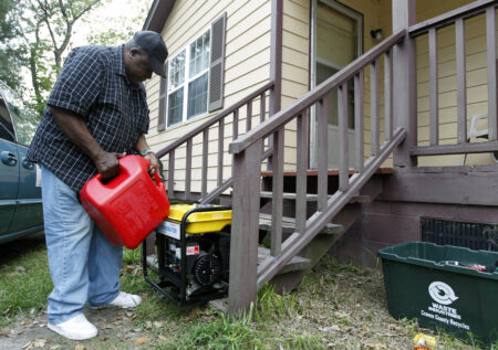 A man pours gasoline in a generator